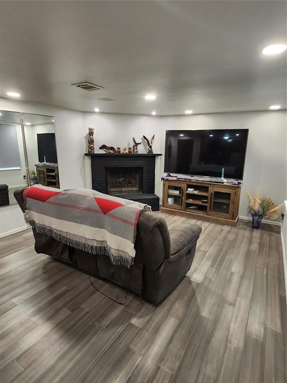 living room with wood-type flooring and a fireplace