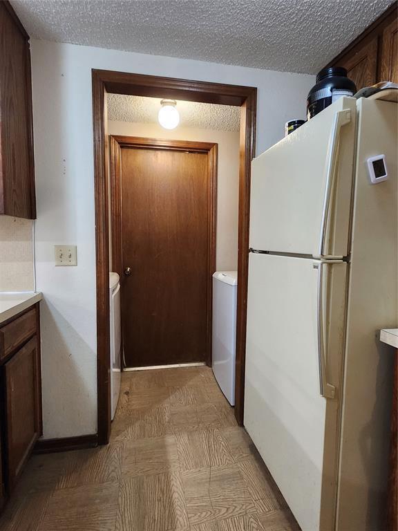 kitchen featuring a textured ceiling and white fridge