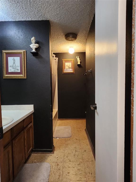 bathroom featuring vanity, a textured ceiling, and walk in shower