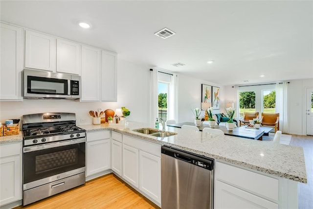 kitchen featuring white cabinetry, appliances with stainless steel finishes, and kitchen peninsula