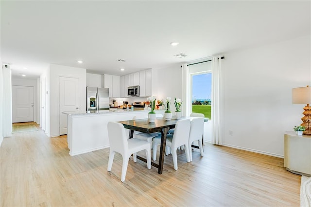 dining space with light hardwood / wood-style flooring