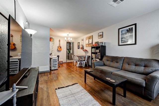 living room with wood-type flooring and a notable chandelier