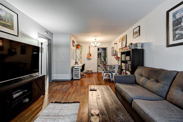 living room featuring wood-type flooring and an inviting chandelier