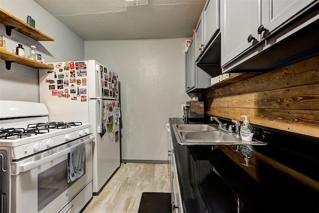 kitchen with white cabinetry, white range with gas cooktop, sink, and light hardwood / wood-style floors