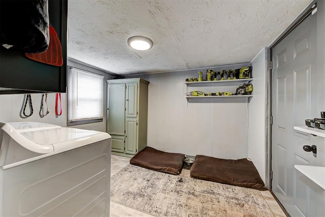 bedroom featuring washer / dryer and a textured ceiling