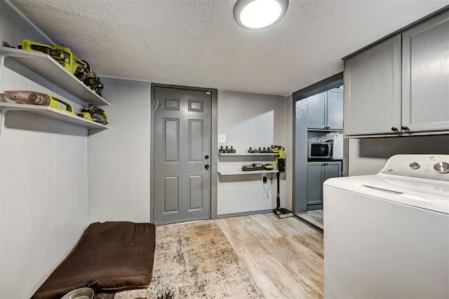 laundry room with washer / clothes dryer, cabinets, and light hardwood / wood-style floors