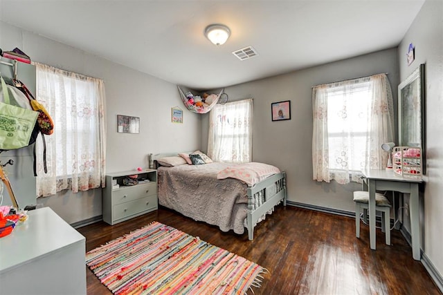 bedroom with dark hardwood / wood-style flooring and multiple windows