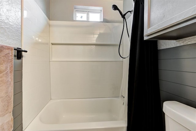 bathroom featuring toilet and tiled shower / bath combo