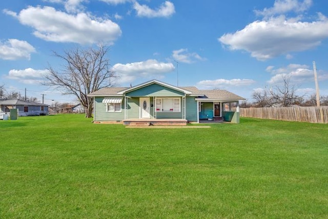 rear view of house with covered porch and a lawn