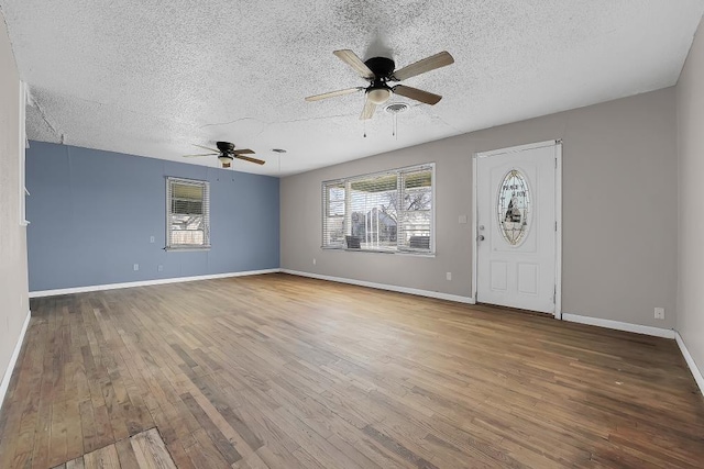 entrance foyer featuring hardwood / wood-style flooring, a wealth of natural light, and a textured ceiling