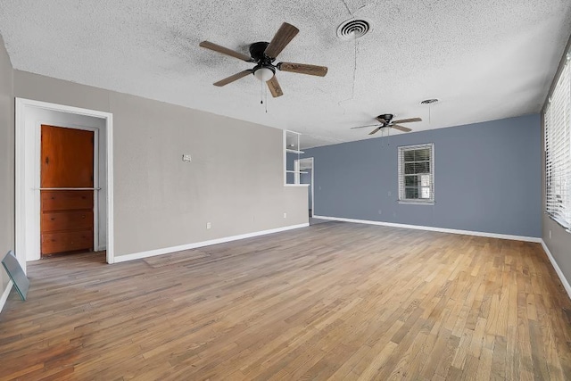 unfurnished living room featuring hardwood / wood-style flooring, ceiling fan, and a textured ceiling