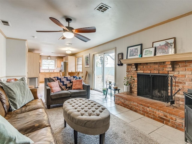 living room featuring light tile patterned floors, ceiling fan, a fireplace, ornamental molding, and wood walls