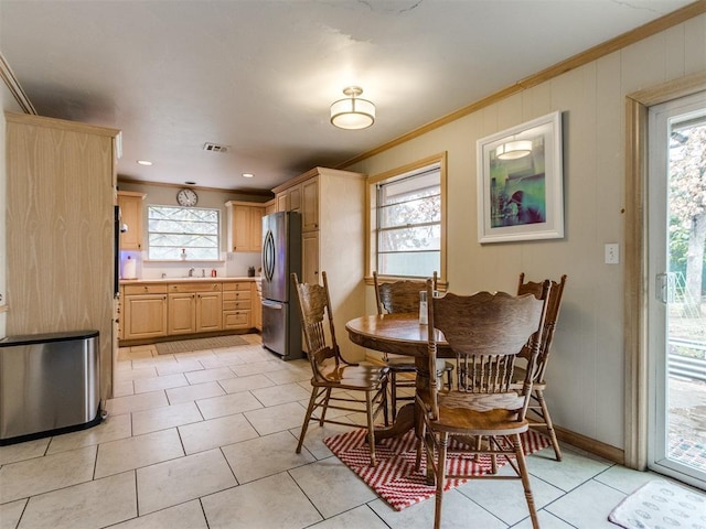 dining space with ornamental molding, sink, and plenty of natural light