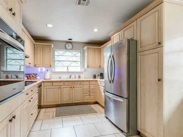 kitchen featuring sink, stainless steel appliances, a healthy amount of sunlight, and light brown cabinets