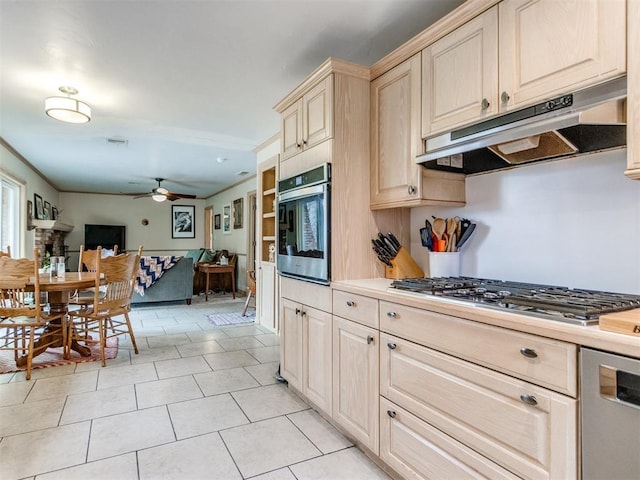 kitchen featuring stainless steel appliances, ceiling fan, and light tile patterned flooring