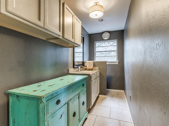 kitchen featuring sink, green cabinets, and light tile patterned floors