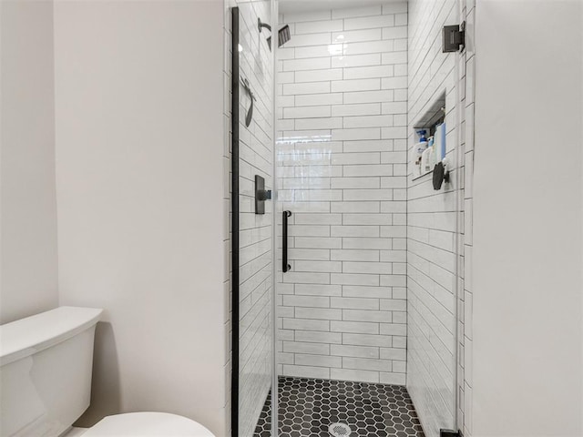 bathroom with a shower with shower door and toilet