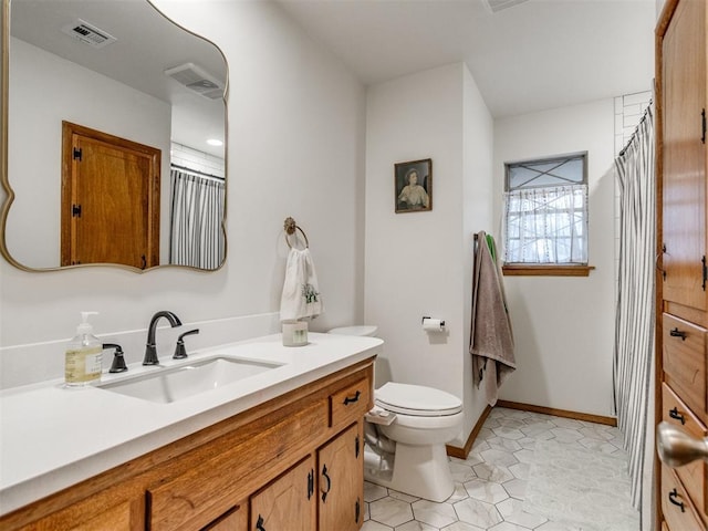 bathroom featuring tile patterned flooring, vanity, and toilet