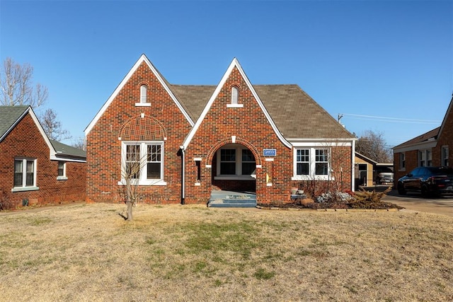 english style home featuring a front lawn