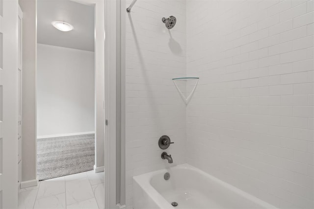 full bath featuring marble finish floor, bathtub / shower combination, and baseboards