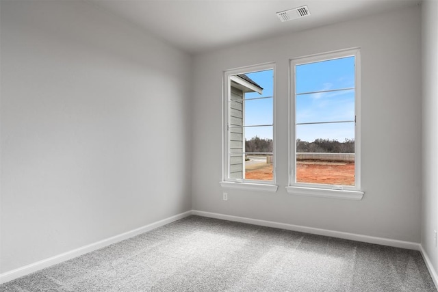 carpeted spare room featuring visible vents and baseboards