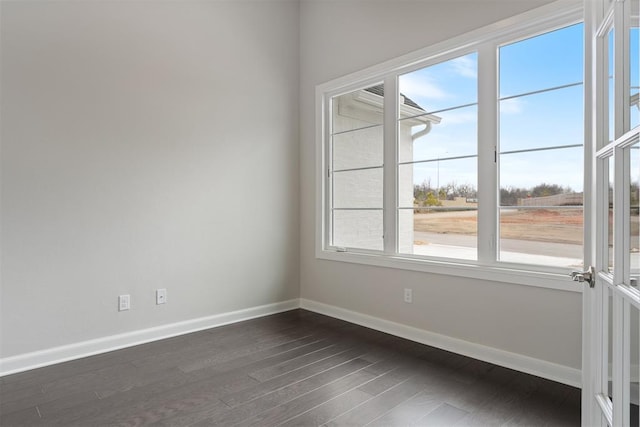 unfurnished room featuring dark wood-style floors and baseboards