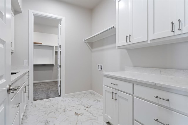 laundry room featuring cabinet space, baseboards, hookup for a washing machine, and marble finish floor