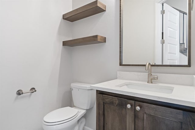 half bathroom featuring vanity and toilet