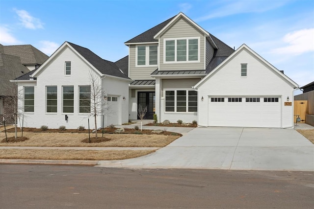 view of front of property with driveway, metal roof, an attached garage, a standing seam roof, and brick siding