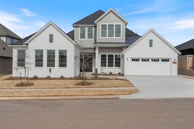 view of front of property featuring metal roof, concrete driveway, a standing seam roof, and a garage