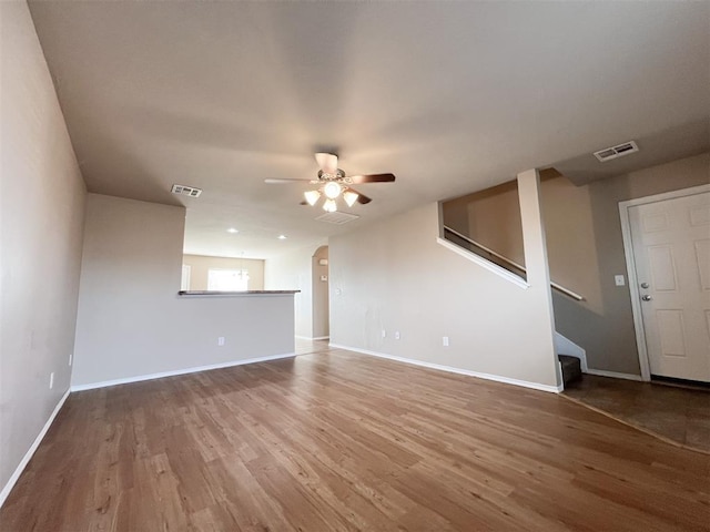 unfurnished living room featuring ceiling fan and hardwood / wood-style floors