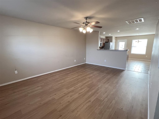 unfurnished living room with dark hardwood / wood-style flooring and ceiling fan