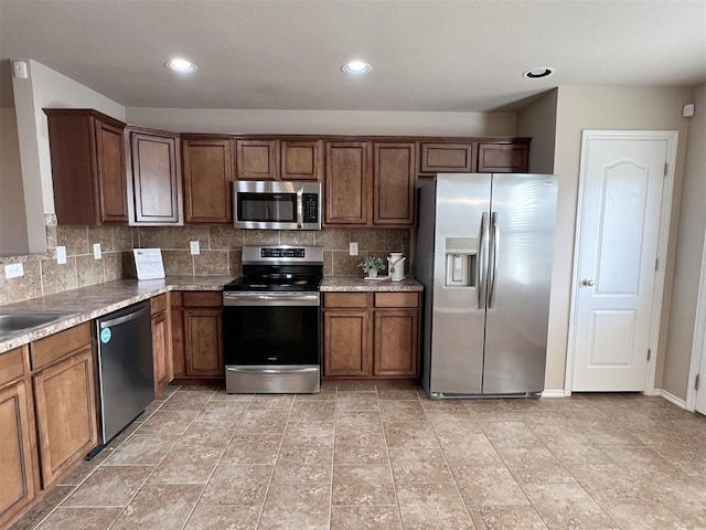 kitchen featuring backsplash, stainless steel appliances, and sink