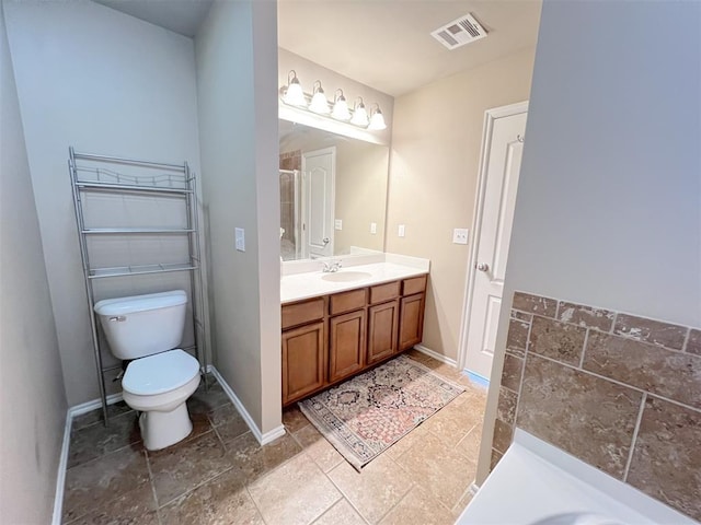 bathroom featuring vanity, walk in shower, and toilet