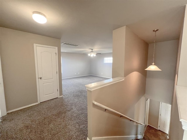 hall with dark colored carpet