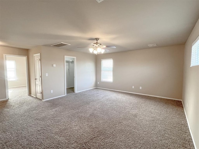 unfurnished room with ceiling fan and carpet