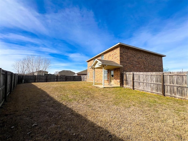 rear view of house with a patio and a yard