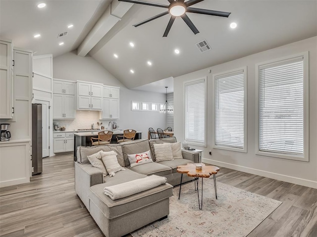 living room featuring high vaulted ceiling, beam ceiling, ceiling fan with notable chandelier, and light hardwood / wood-style flooring