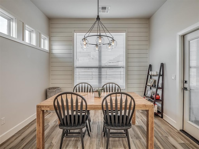 dining area with hardwood / wood-style floors and wood walls