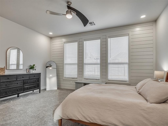 carpeted bedroom featuring multiple windows and ceiling fan