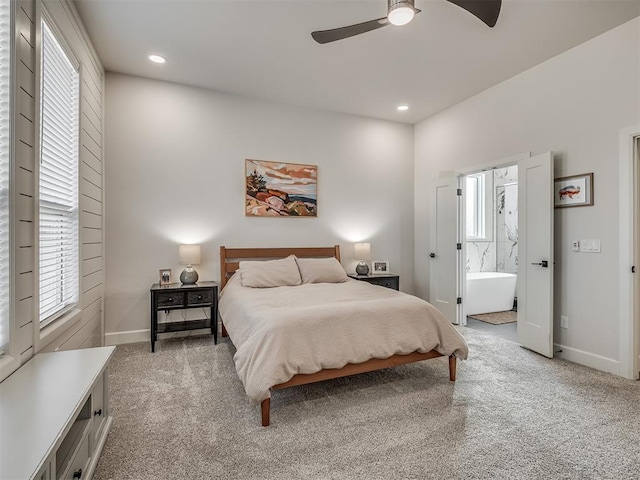 carpeted bedroom featuring multiple windows, connected bathroom, and ceiling fan