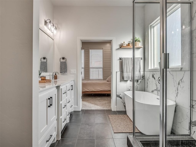 bathroom with vanity, a tub, and tile patterned floors