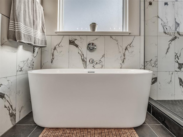 bathroom with tile patterned flooring and a washtub