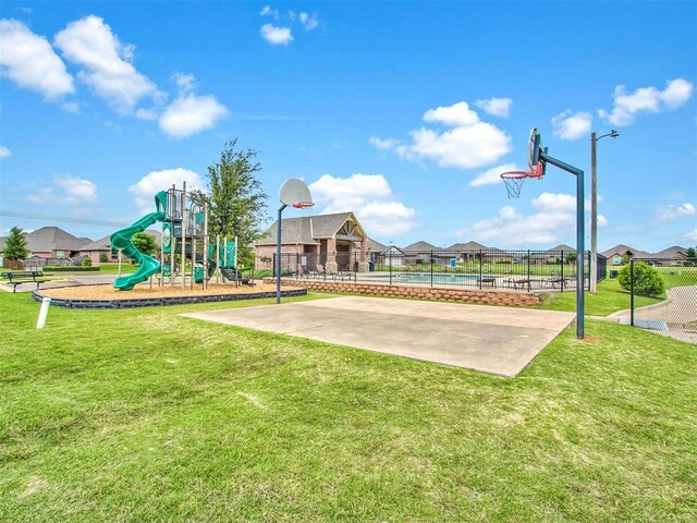 view of play area featuring basketball hoop and a lawn