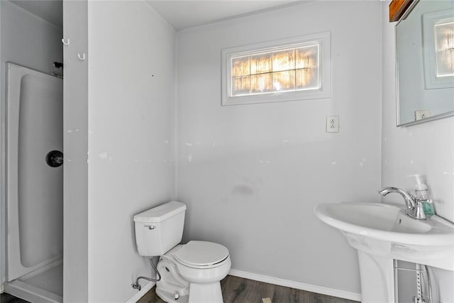 bathroom with toilet, hardwood / wood-style floors, and walk in shower