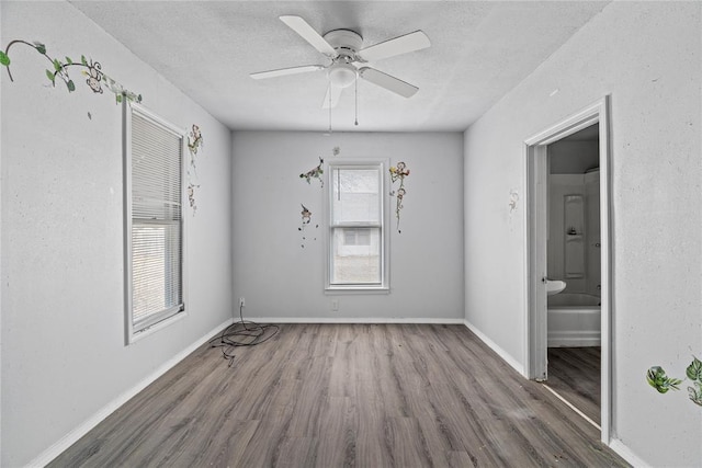 spare room with dark wood-type flooring, ceiling fan, and a textured ceiling