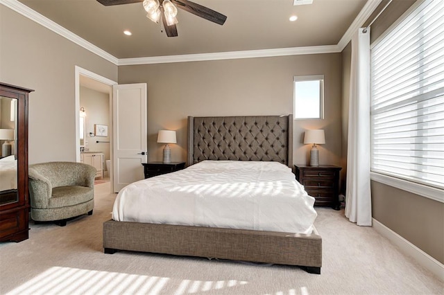 carpeted bedroom with ornamental molding, ceiling fan, and ensuite bath