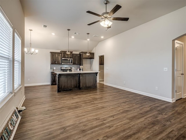 kitchen featuring hanging light fixtures, appliances with stainless steel finishes, a kitchen island with sink, and dark brown cabinets