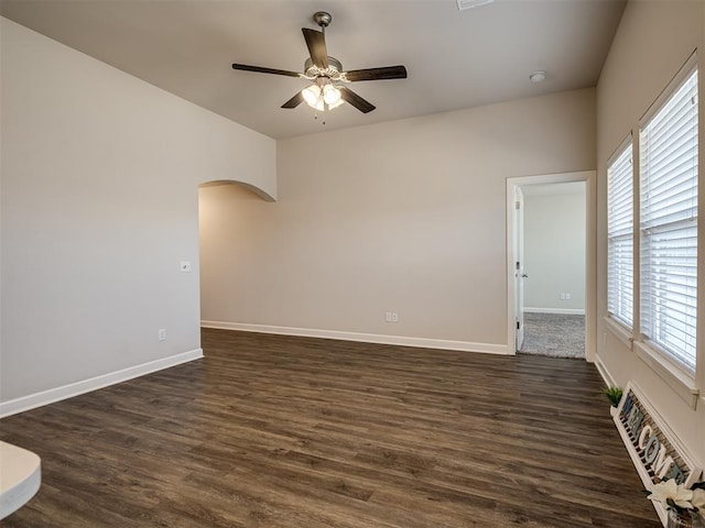 empty room featuring dark wood-type flooring and ceiling fan