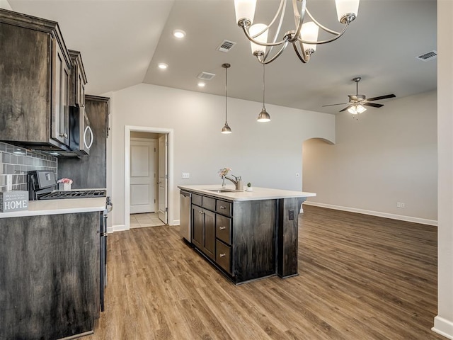 kitchen with sink, decorative light fixtures, dark brown cabinets, a center island with sink, and stainless steel appliances